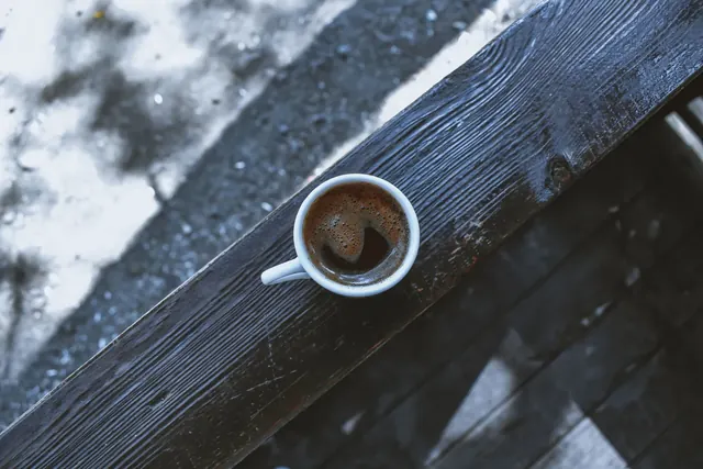Kahvikuppi ylhäältä kuvattuna puisella pöydällä