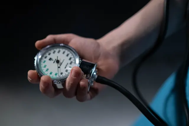 Käsi pitelee verenpainemittarin viisaritaulua