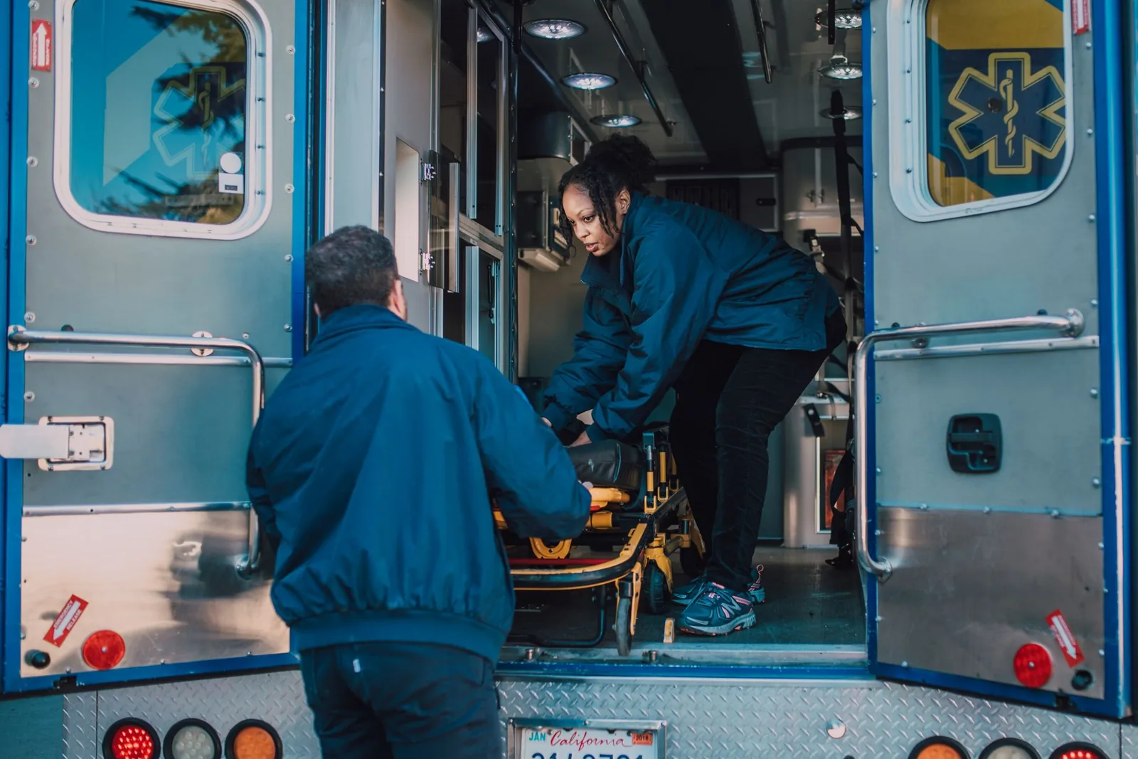 Ensihoitajat nostavat paaria ambulanssiin