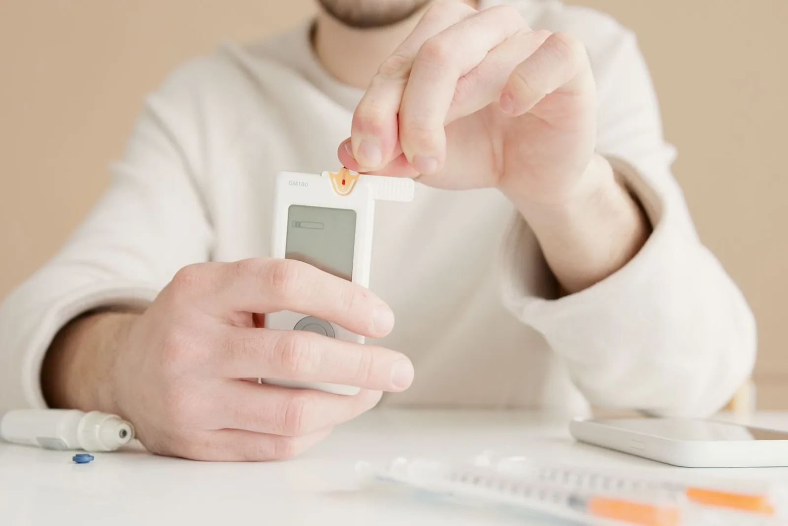 Henkilö testaa verensokeriaan mittarilla pöydän ääressä
